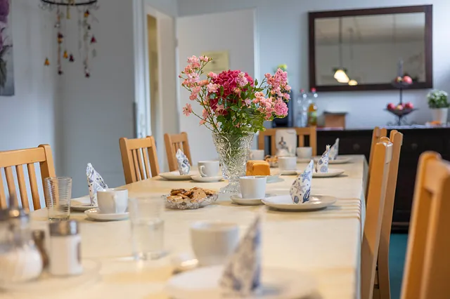 Ein gedeckter Tisch mit einer Vase mit Blumen darin
