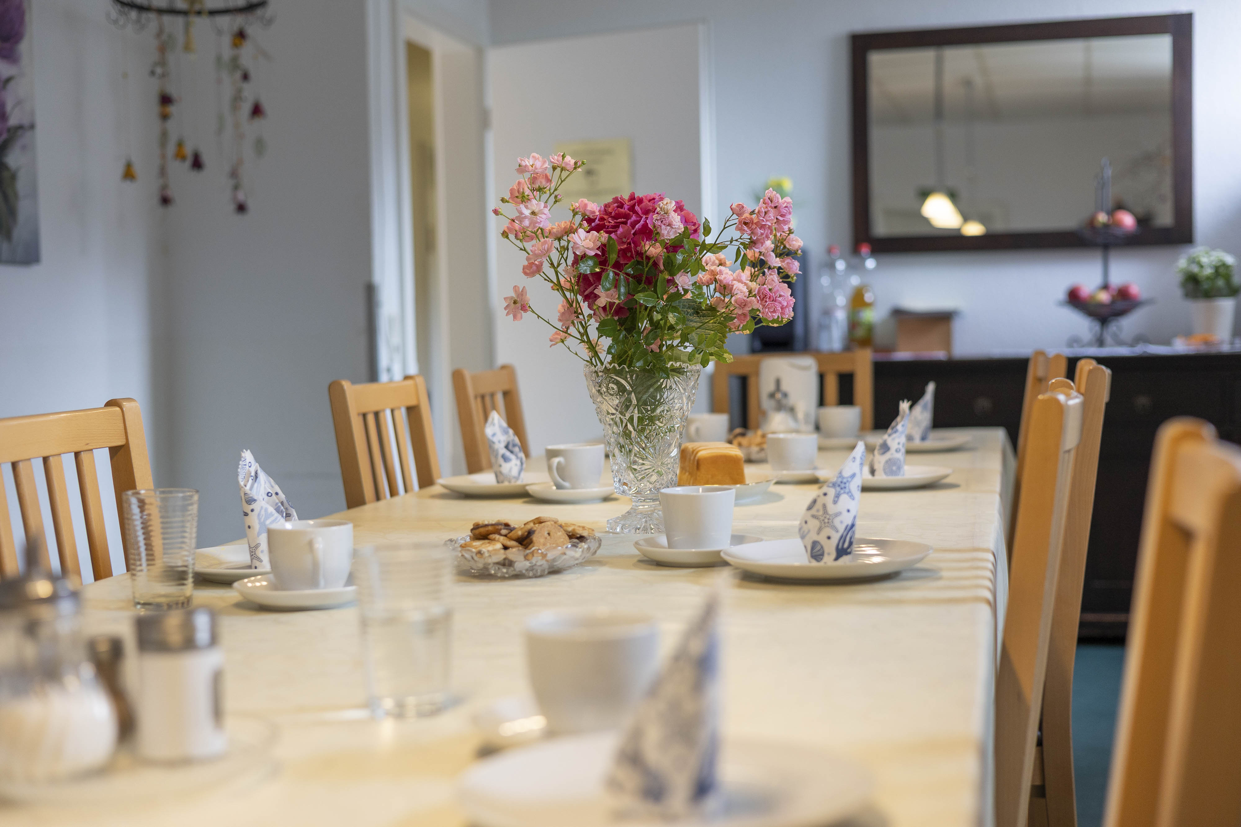 Ein gedeckter Tisch mit einer Vase mit Blumen darin